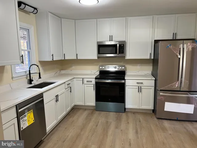 a kitchen with stainless steel appliances a stove microwave and sink