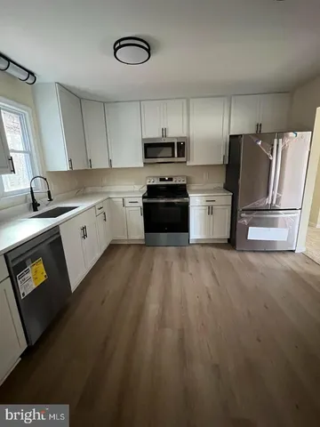 a kitchen with granite countertop a refrigerator stove top oven and sink
