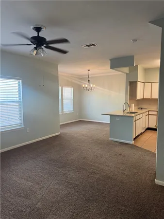 a view of a livingroom with a fireplace a ceiling fan and wooden floor