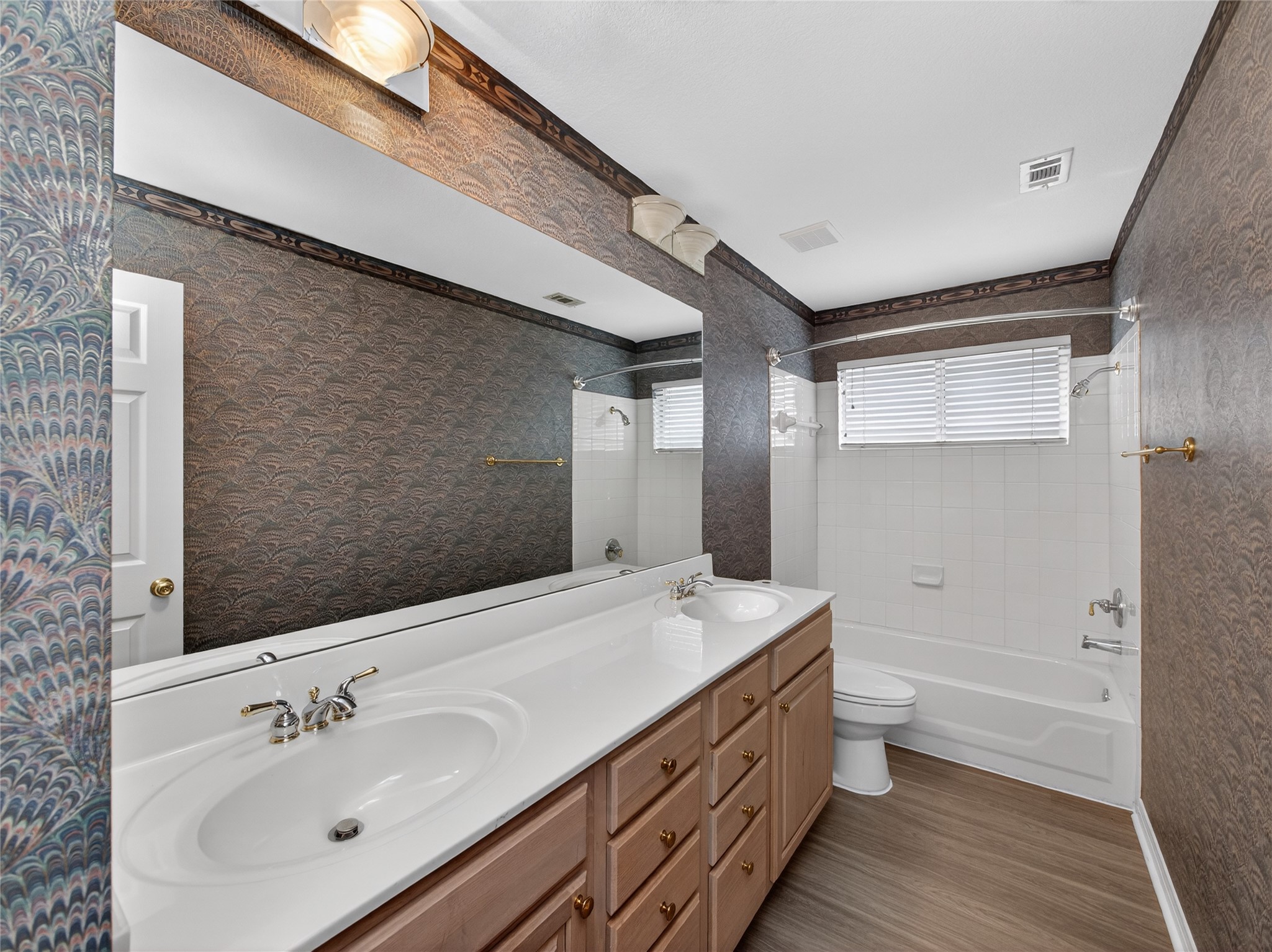 11029 Ballybunion Place Austin, TX 78747 - Photo 31 of 40 a bathroom with a double vanity sink a mirror and a bathtub