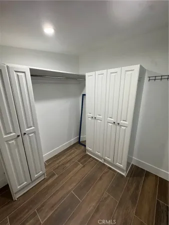 an empty room with wooden floor and entrance