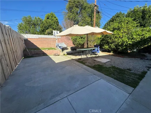 a view of a patio with chairs under an umbrella