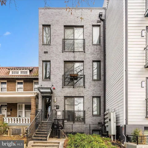 a front view of a residential apartment building with a yard