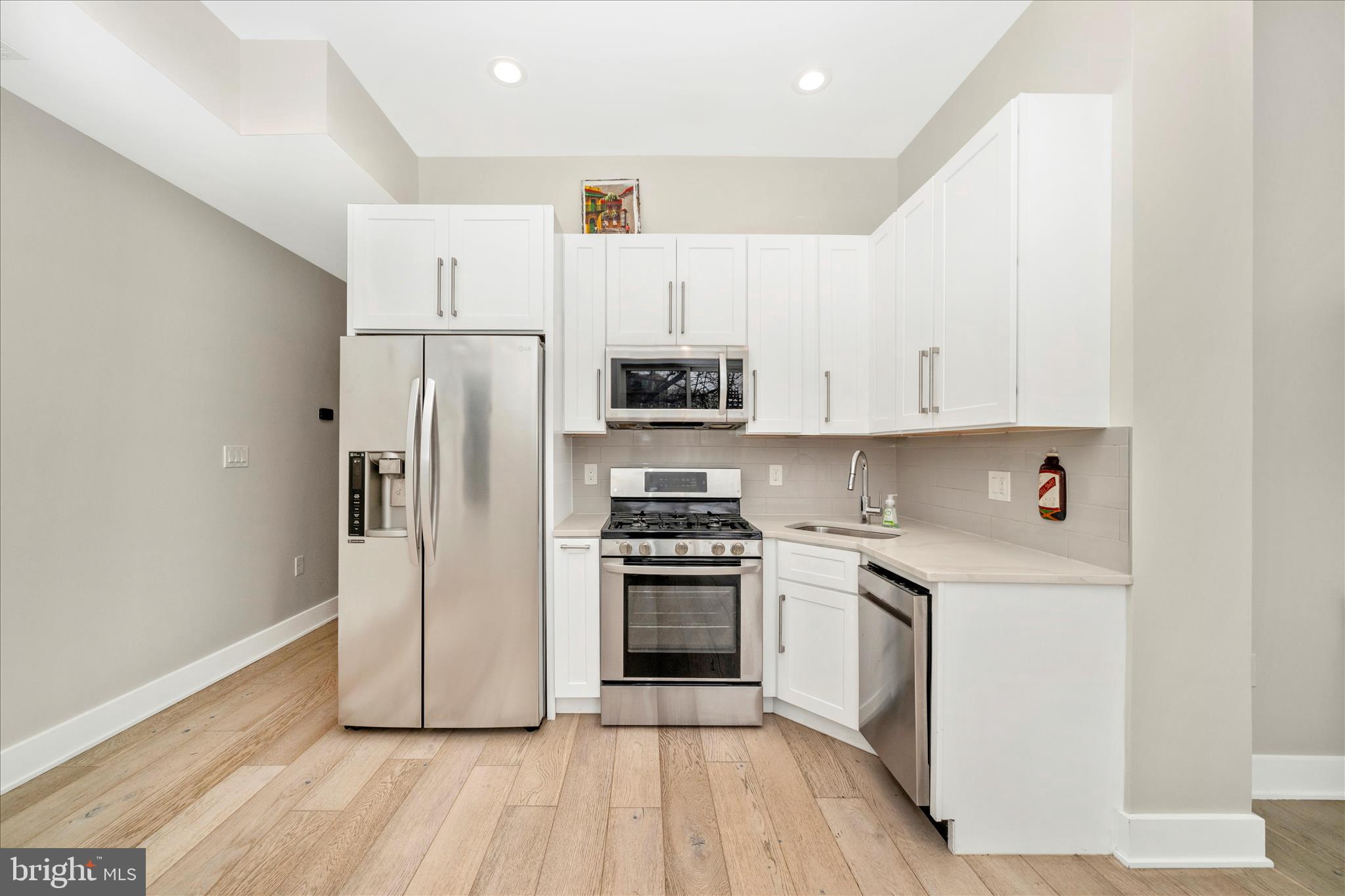 7129 Georgia Avenue Northwest, Unit 4 Washington, DC 20012 - Photo 8 of 30 a kitchen with cabinets stainless steel appliances and wooden floor