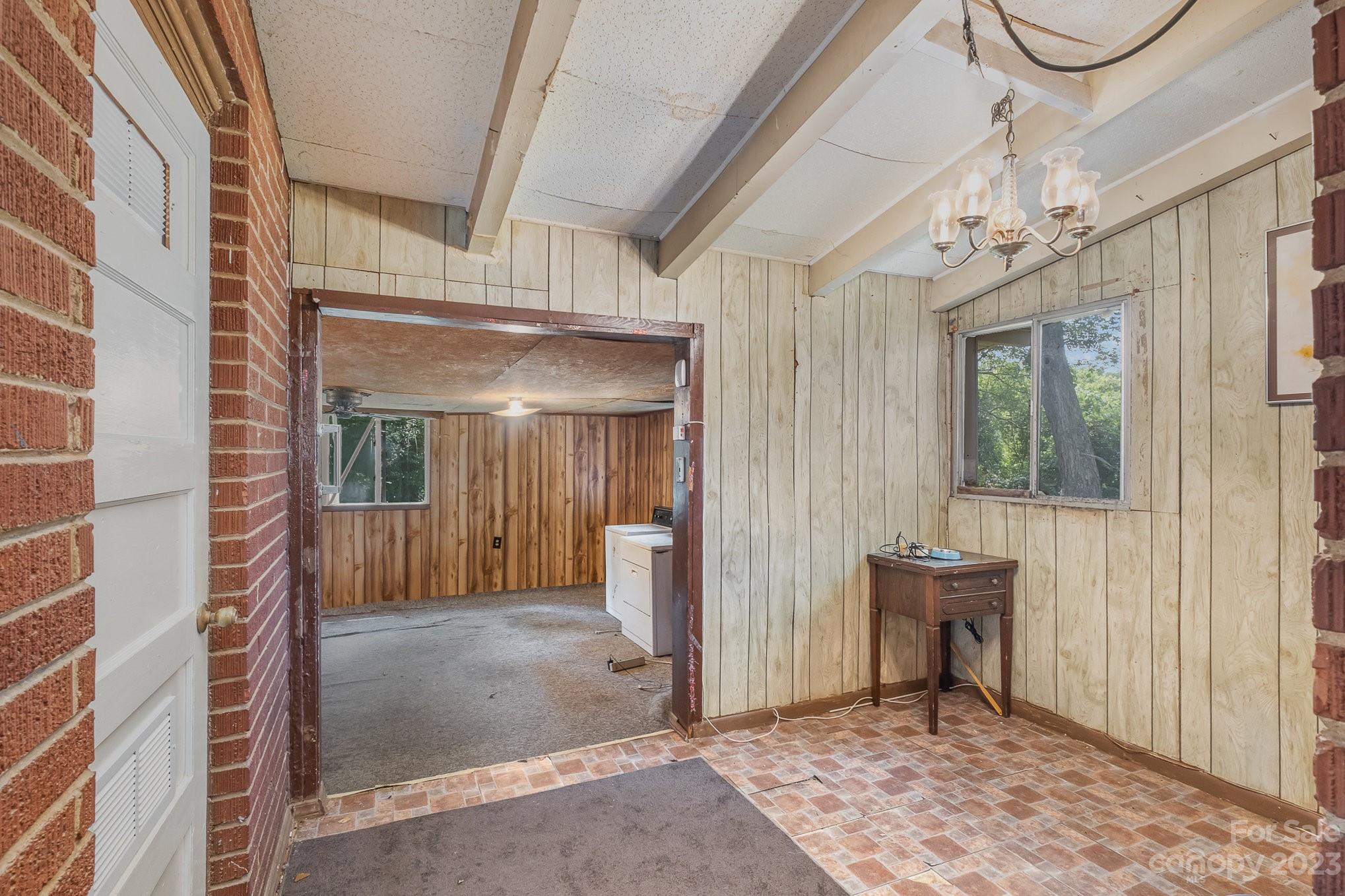 1139 Clanton Road Charlotte, NC 28217 - Photo 11 of 22 a view of a hallway with wooden floor and a chandelier