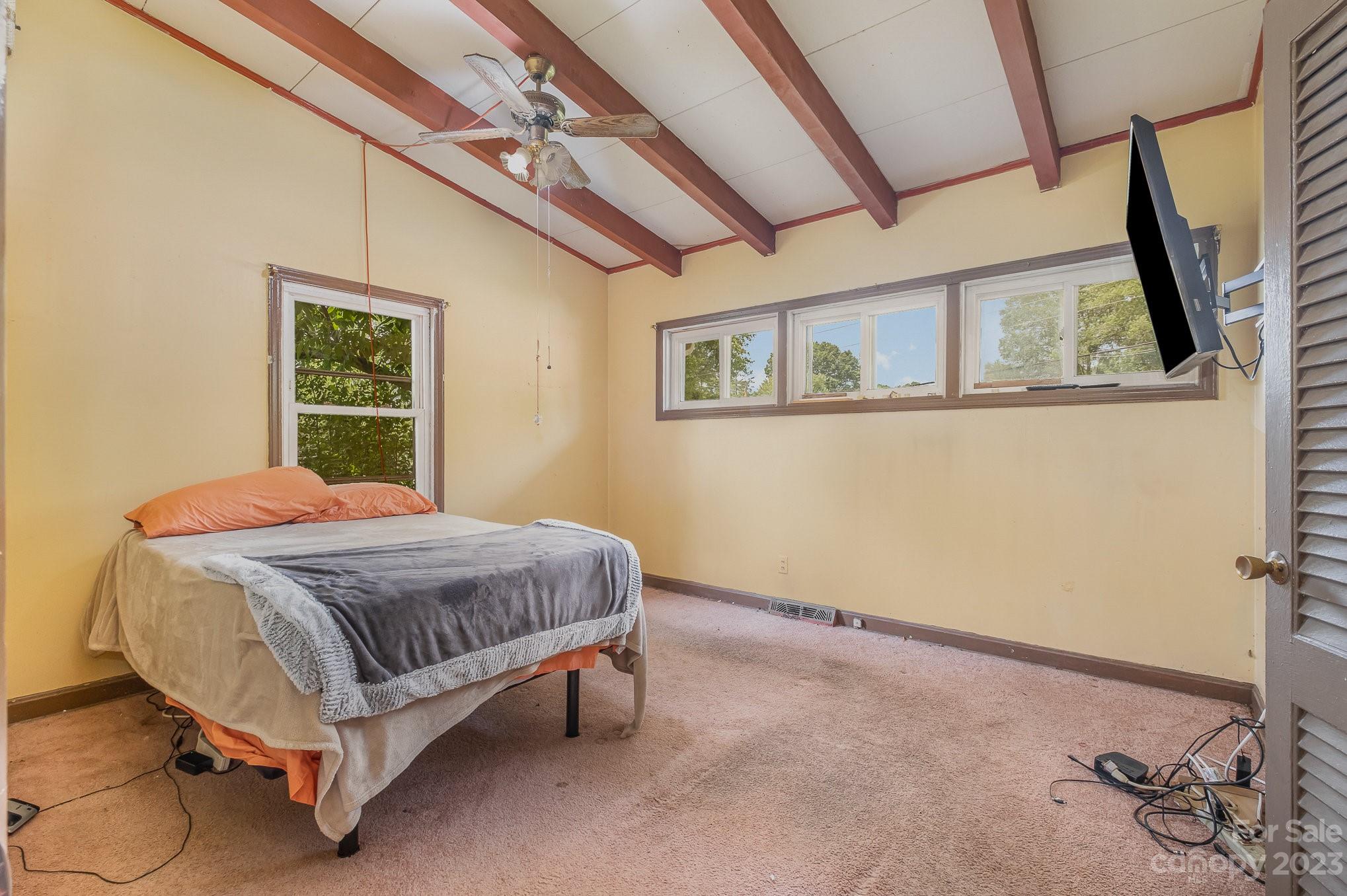 1139 Clanton Road Charlotte, NC 28217 - Photo 17 of 22 a bed sitting in a bedroom next to a window