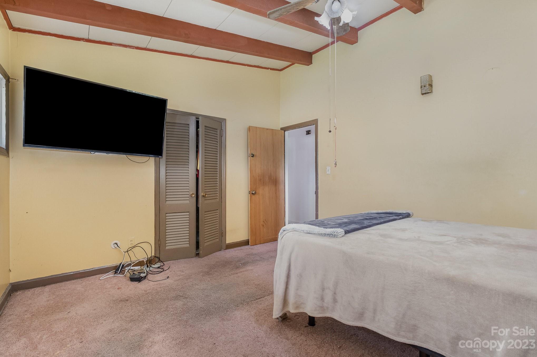 1139 Clanton Road Charlotte, NC 28217 - Photo 18 of 22 a bedroom with a bed and a flat screen tv