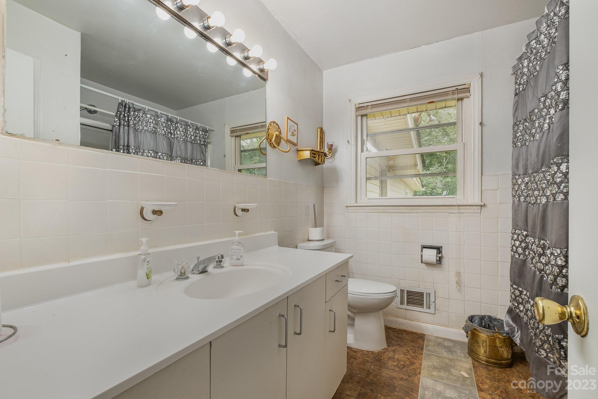 1139 Clanton Road Charlotte, NC 28217 - Photo 19 of 22 a bathroom with a sink a toilet and a mirror