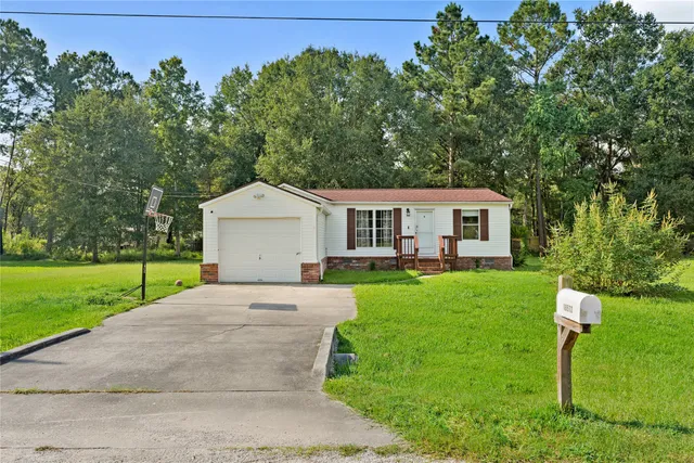 a house with green field in front of it