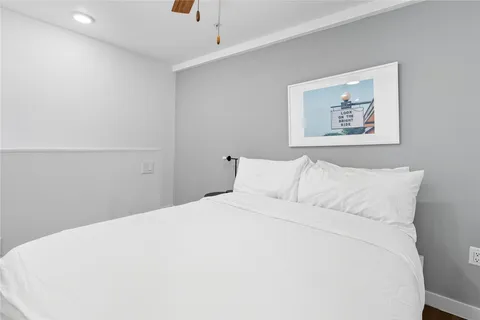 a bedroom with a large bed and a ceiling fan