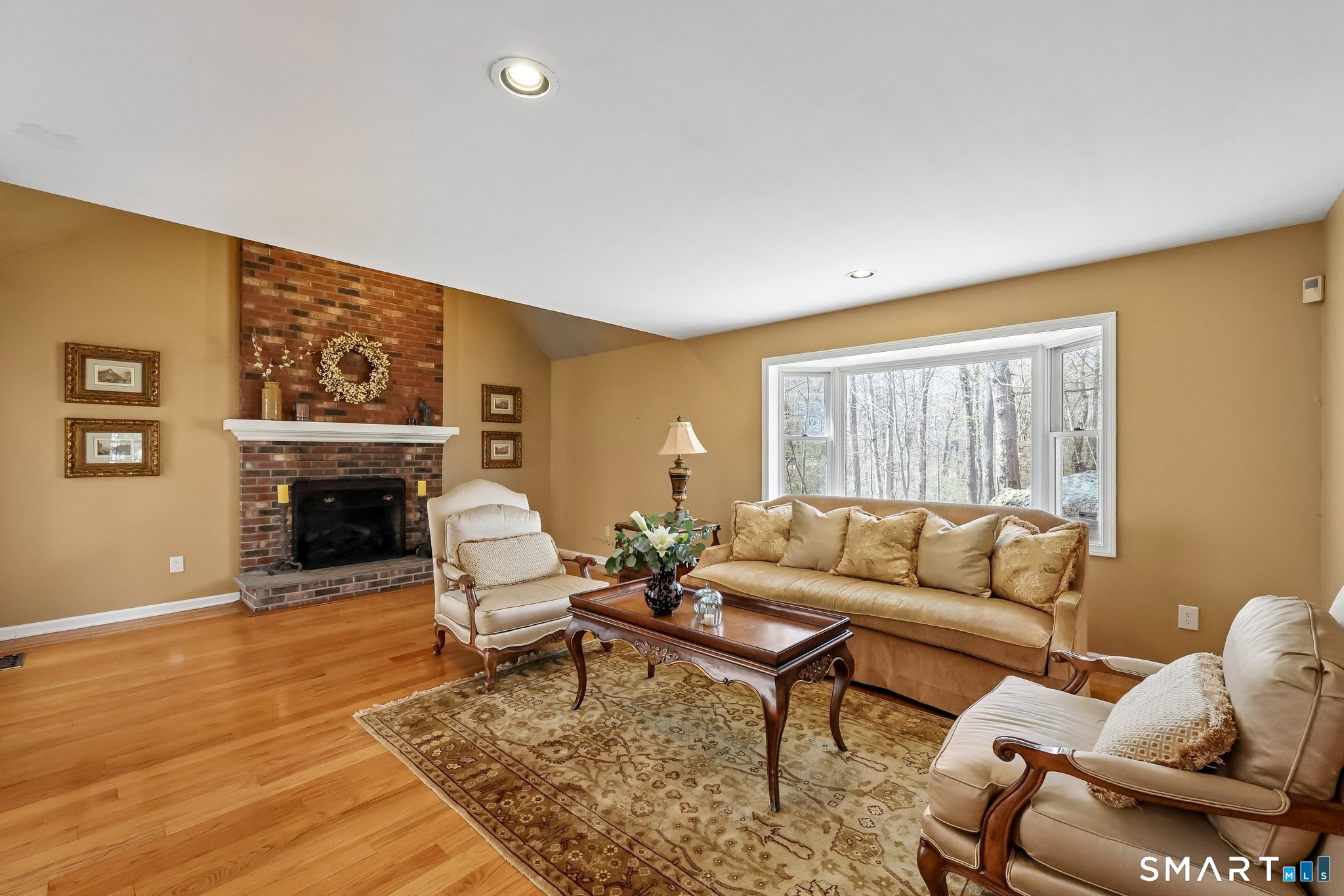 86 Quail Run Madison, CT 06443 - Photo 10 of 37 The family room has a large bay window, and a gas fireplace. Above the brick fireplace is a vaulted ceiling