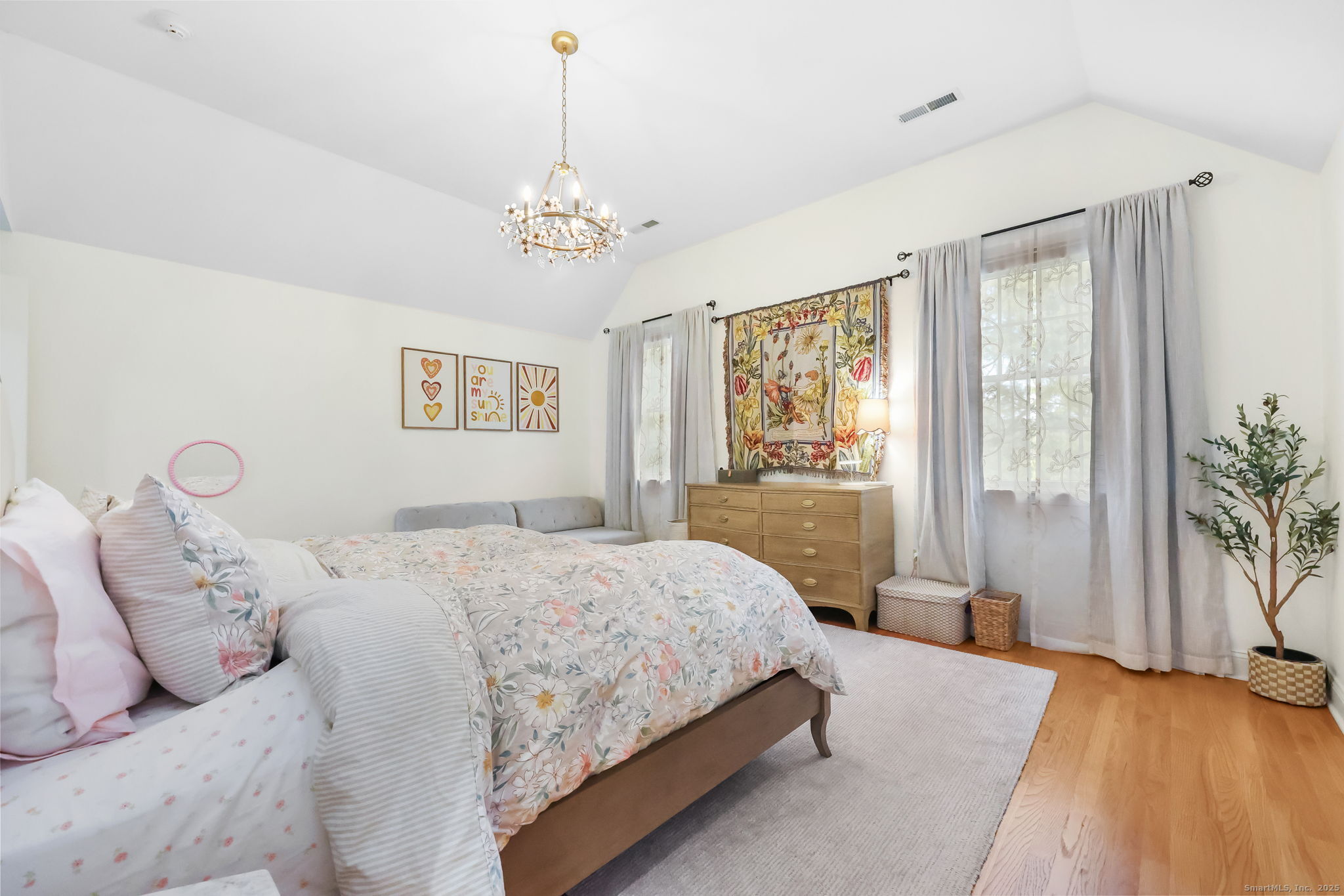 76 Hilary Circle, Unit 76 Fairfield, CT 06825 - Photo 15 of 29 a bedroom with a large bed and a chandelier