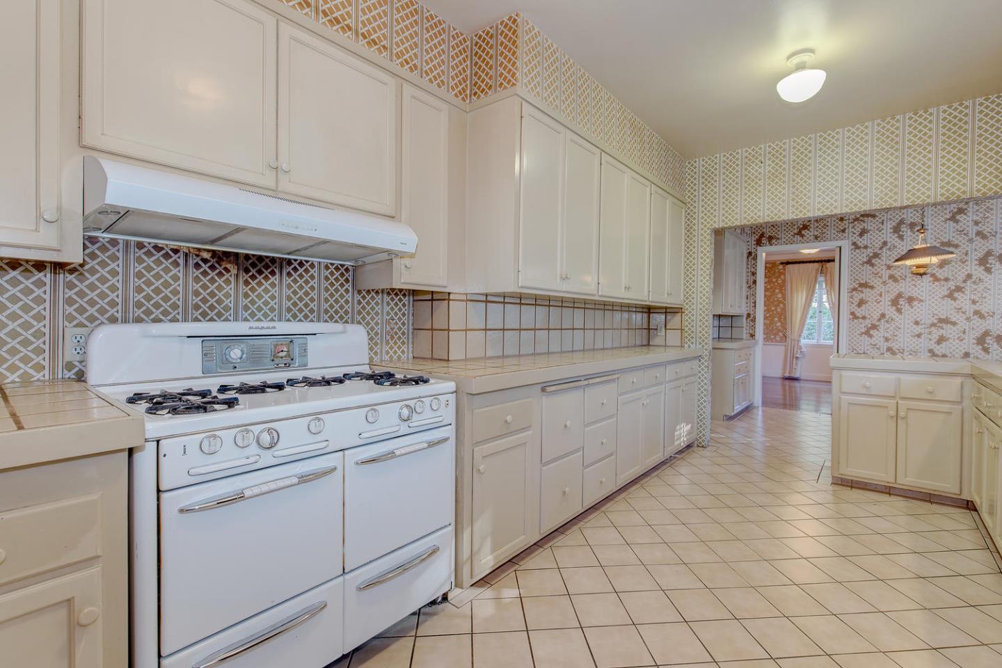 540 Roehampton Road Hillsborough, CA 94010 - Photo 10 of 27 a kitchen with white cabinets and white appliances