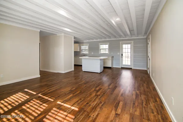 a view of a room with wooden floor and window