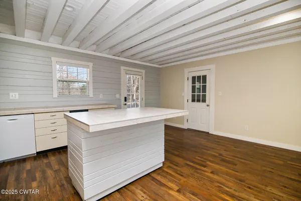 a kitchen with granite countertop a sink a counter space cabinets and stainless steel appliances
