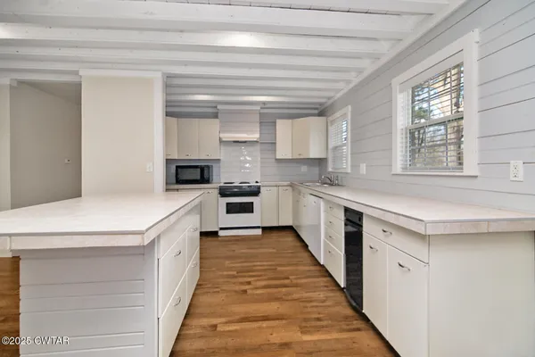 a kitchen with stainless steel appliances granite countertop a sink a stove and a refrigerator