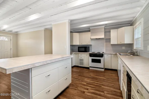 a kitchen with stove cabinets and wooden floor