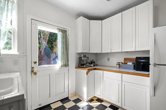 a kitchen with stainless steel appliances white cabinets and a window
