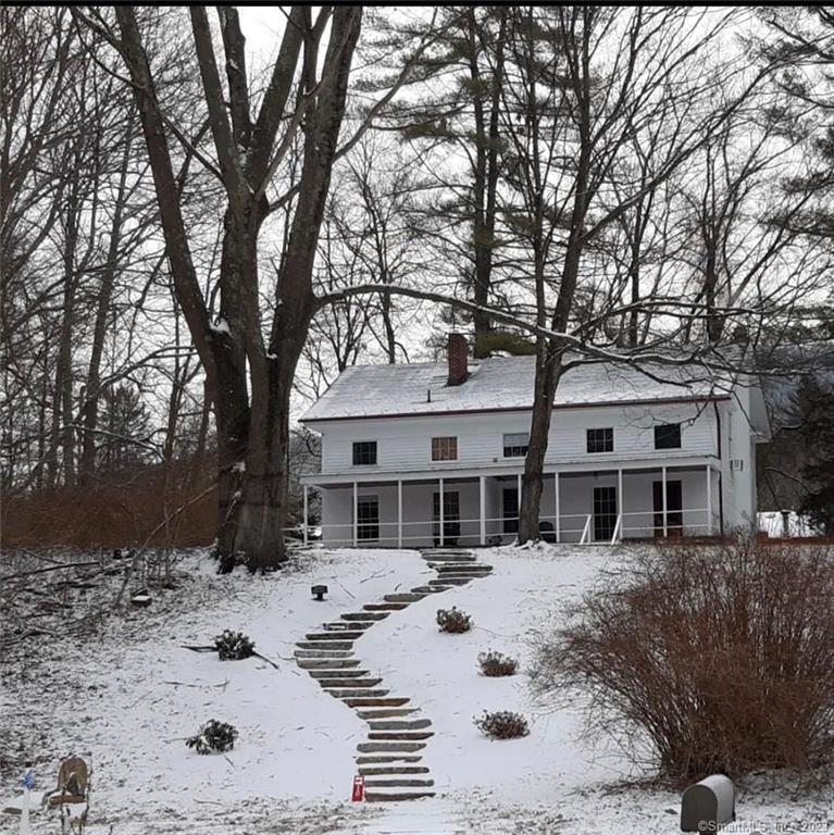 a view of a white house with a yard covered in snow