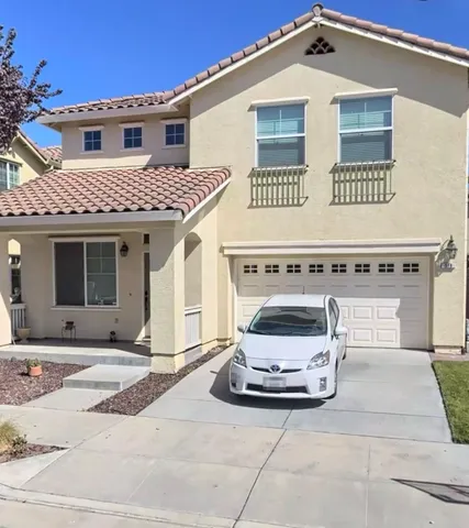 a view of a house with a barbeque and large trees