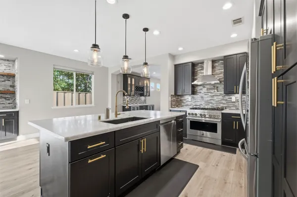 a kitchen with stainless steel appliances granite countertop a sink stove and refrigerator