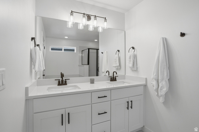 11531 Engelmann Drive Draper, UT 84020 - Photo 16 of 31 Dual vanity with white cabinetry and integrated sinks, complemented by dark bronze fixtures and hardware