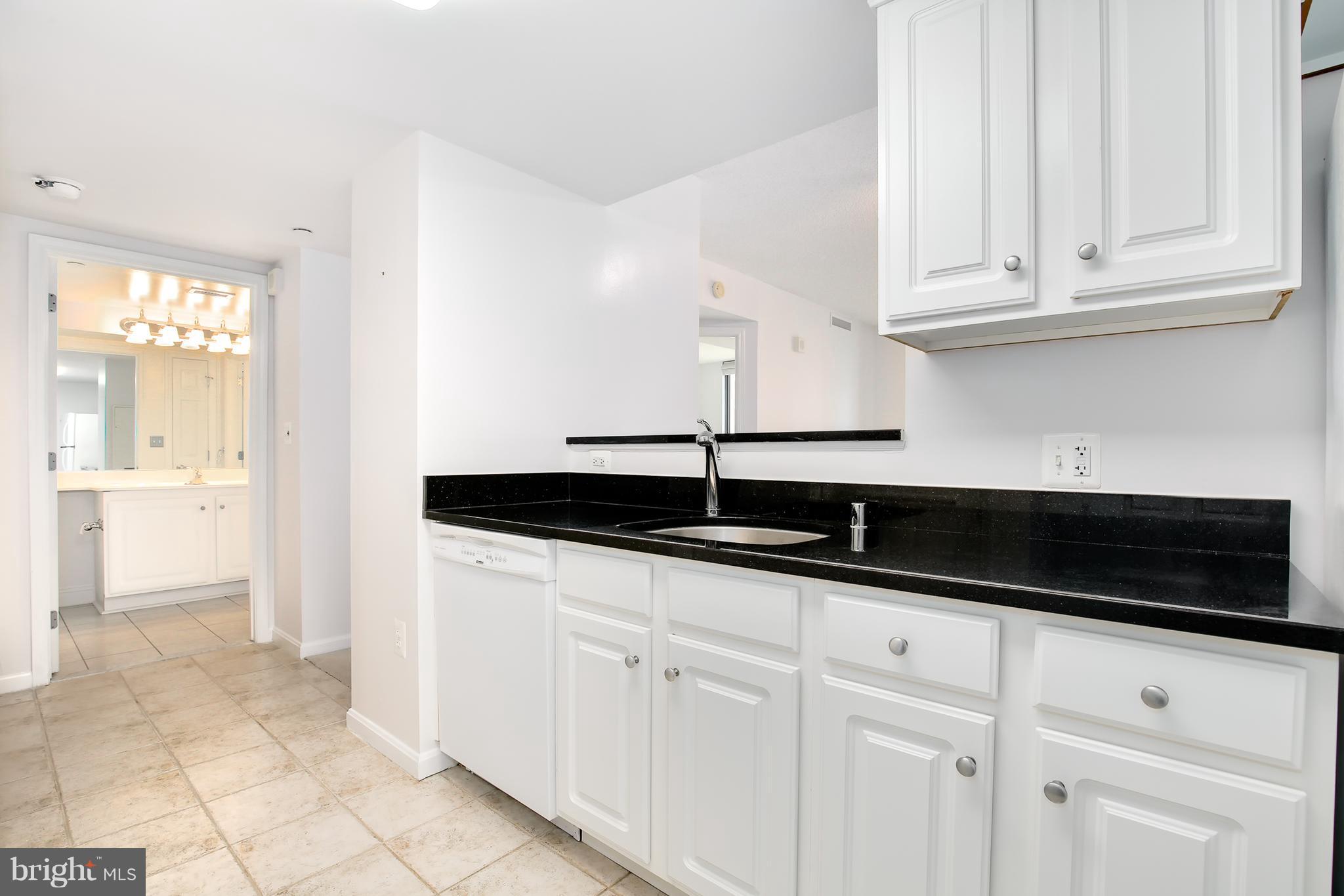 11710 Old Georgetown Road, Unit 1124 North Bethesda, MD 20852 - Photo 5 of 30 a kitchen with granite countertop white cabinets and sink