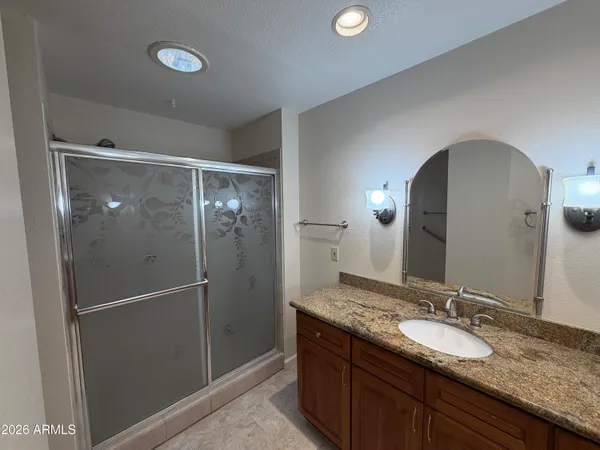 an empty room with windows and chandelier fan