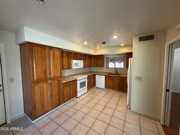 a kitchen with stainless steel appliances granite countertop a refrigerator and a sink