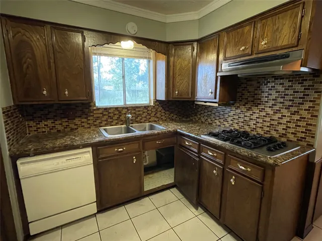 a kitchen with granite countertop cabinets a sink stainless steel appliances and a window