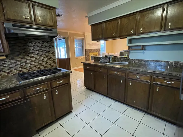 a kitchen with stainless steel appliances granite countertop a sink stove and cabinets
