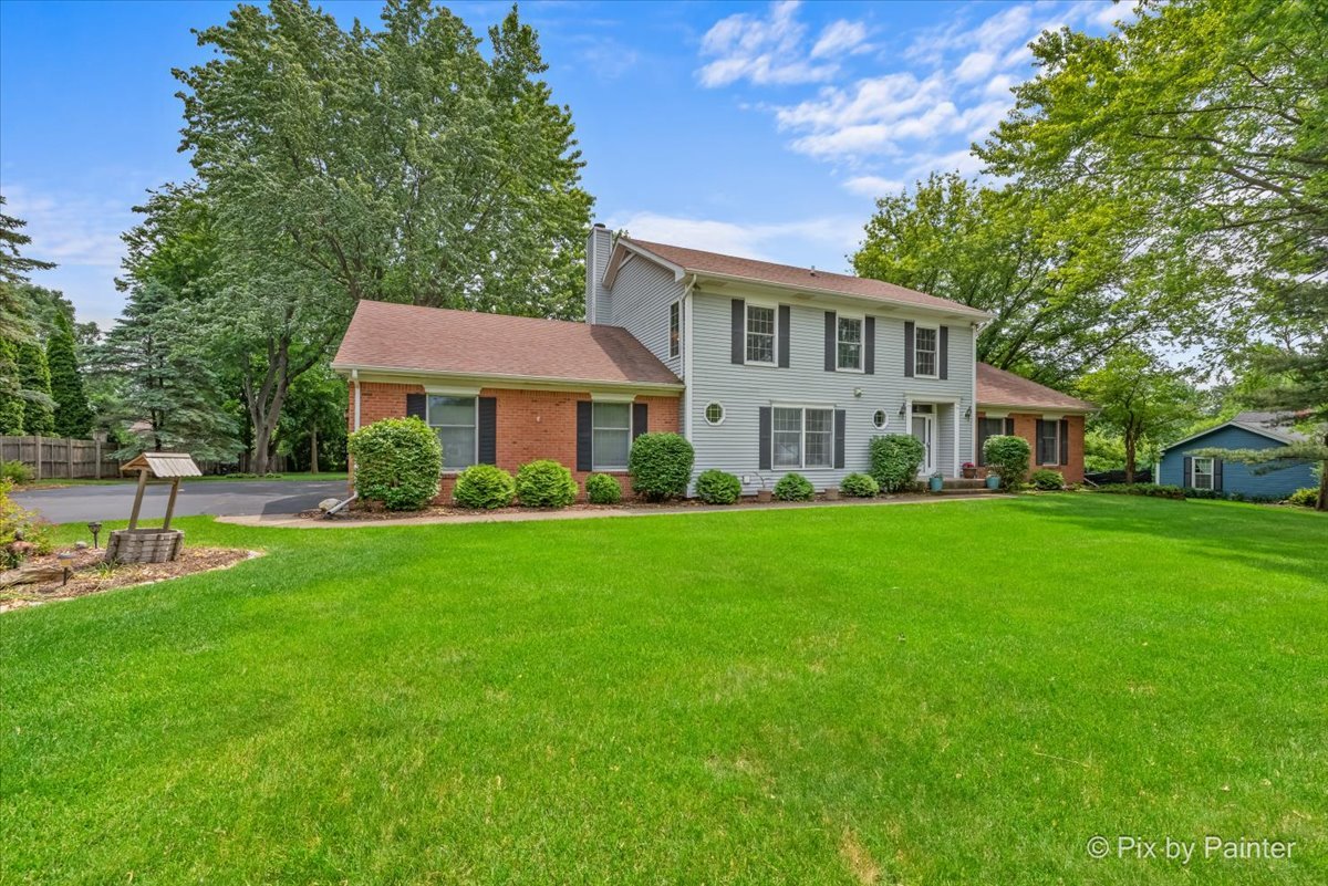a front view of a house with a yard table and trees