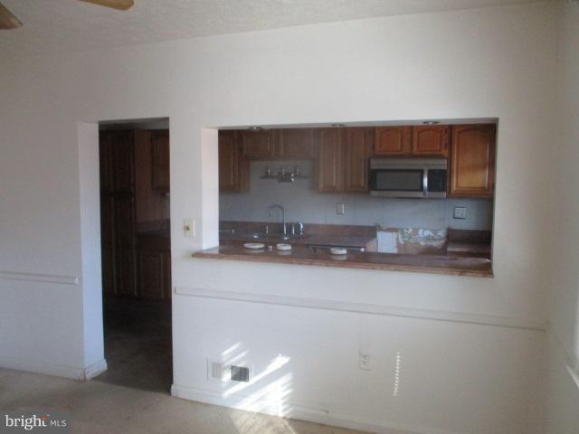 6125 Dunroming Road Baltimore, MD 21239 - Photo 6 of 21 a kitchen with a sink and a refrigerator