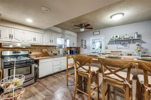a kitchen with a table chairs stove and cabinets