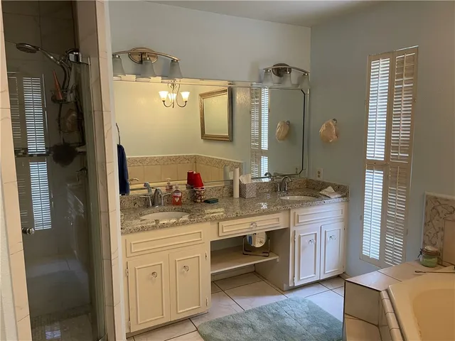 a bathroom with a granite countertop sink a mirror and a shower