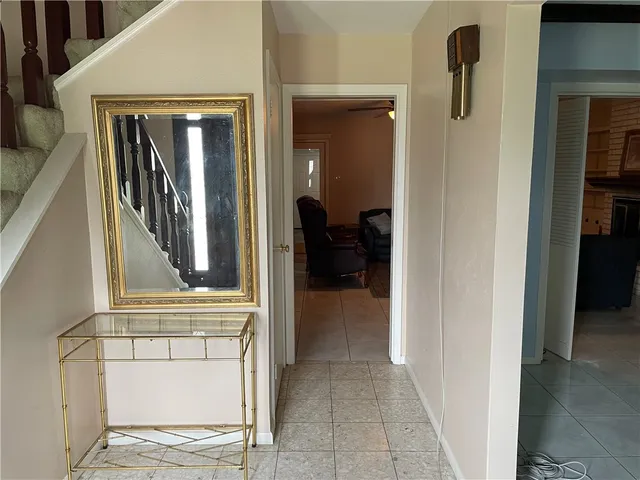 a view of hallway with mirror and furniture