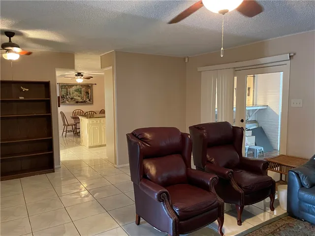 a living room with furniture and a ceiling fan