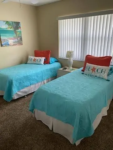 a bedroom with two beds and chair