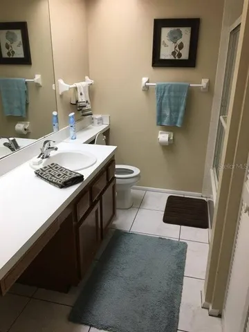a bathroom with a toilet a sink and mirror