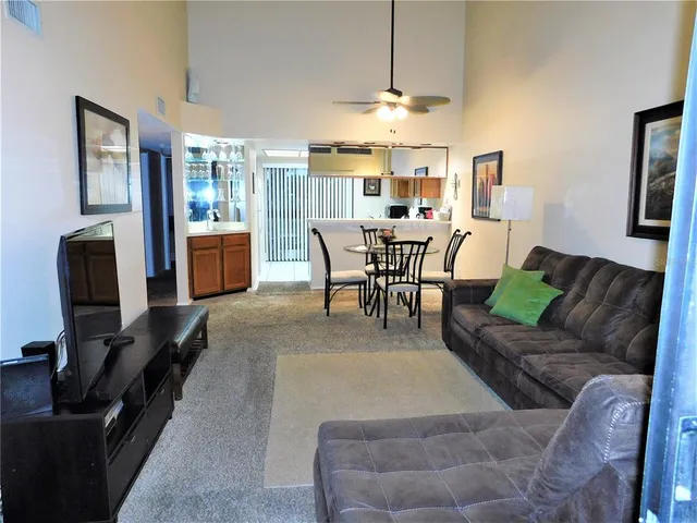 a living room with furniture a chandelier and a flat screen tv