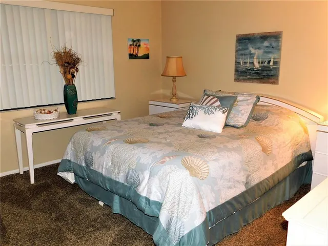 a bedroom with bed and a painting on the wall