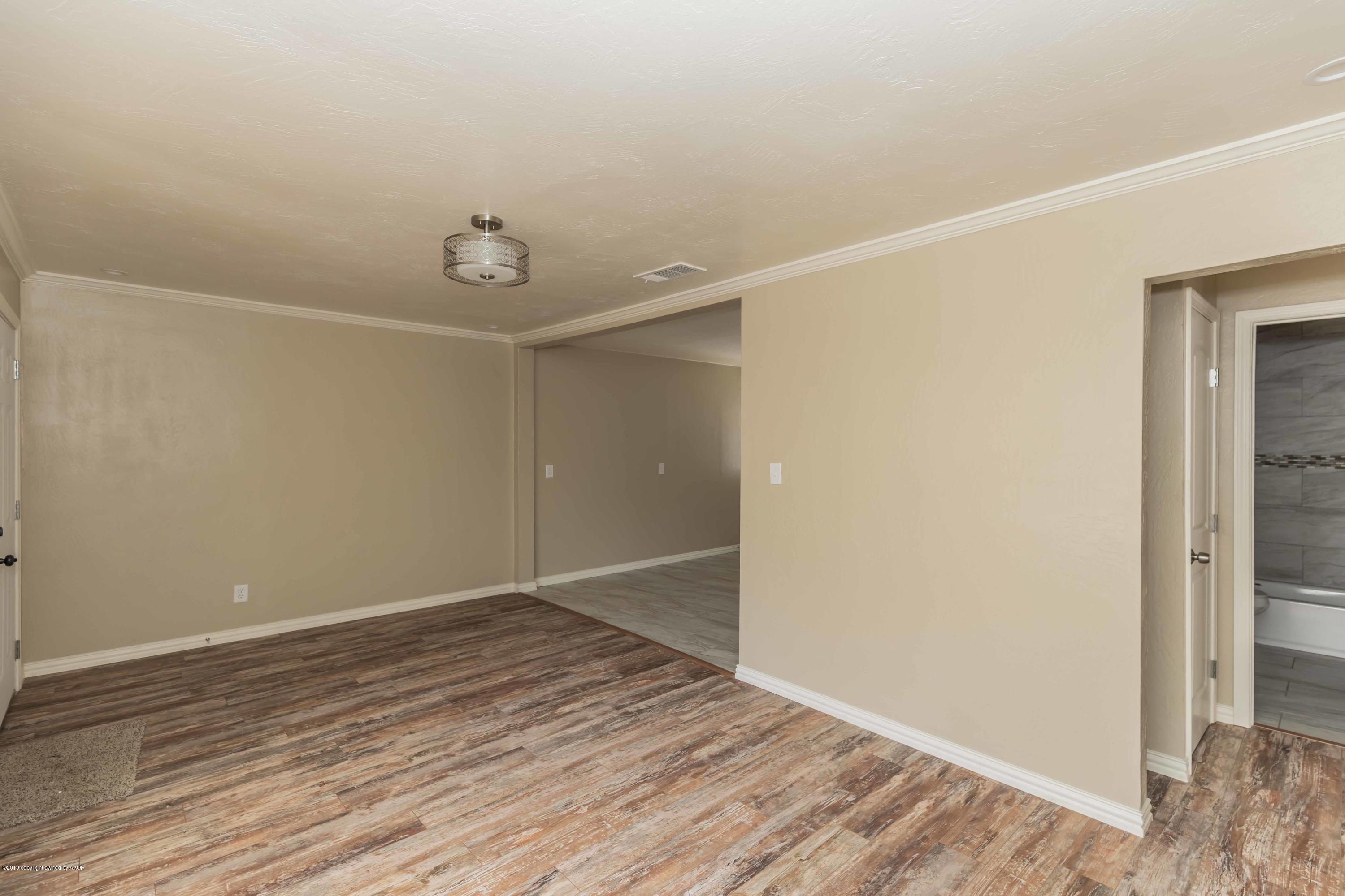 1410 Southwest 46th Avenue Amarillo, TX 79110 - Photo 4 of 29 an empty room with wooden floor and windows