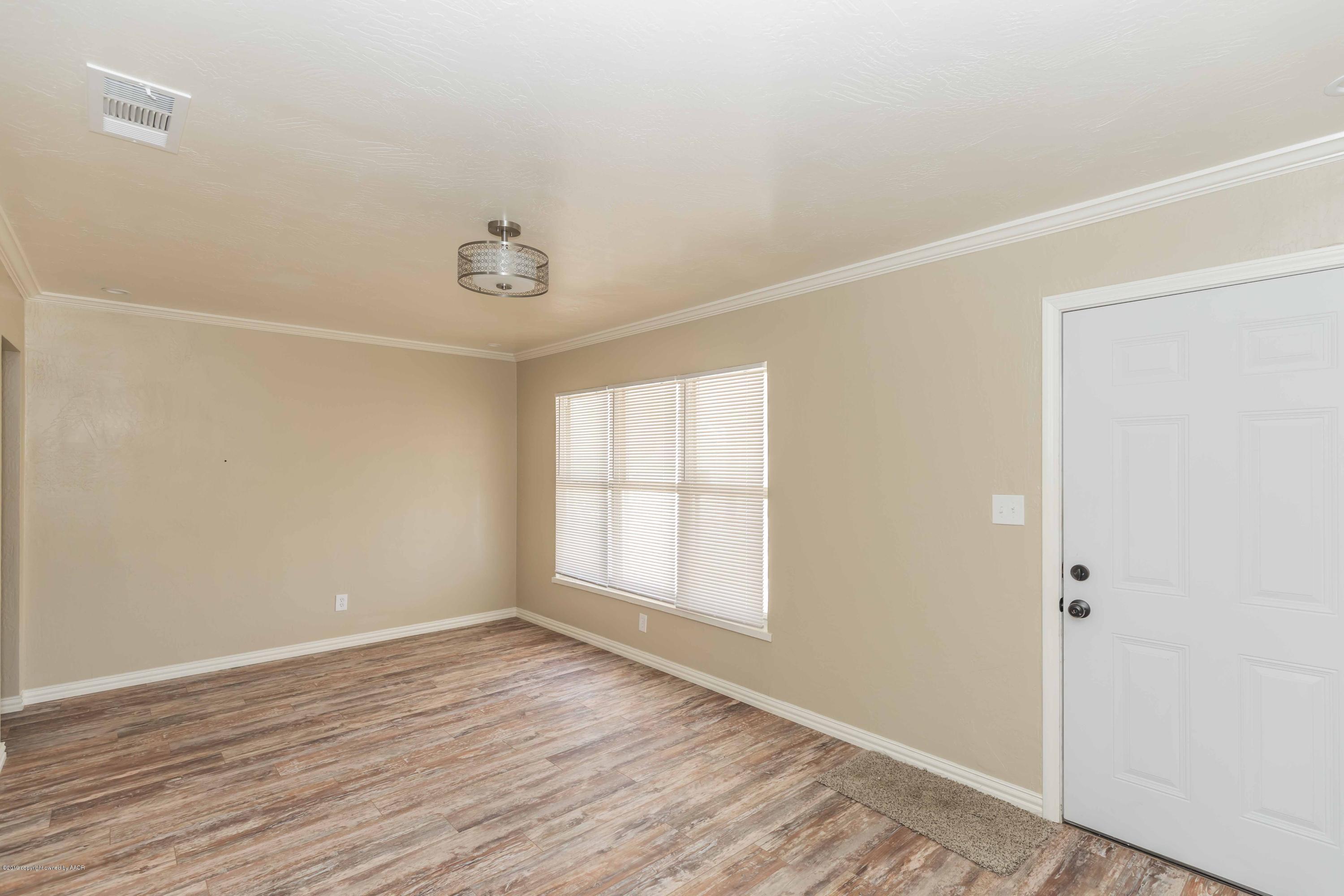1410 Southwest 46th Avenue Amarillo, TX 79110 - Photo 6 of 29 an empty room with wooden floor and windows