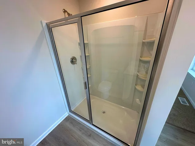 a bathroom with a glass door shower and a sink
