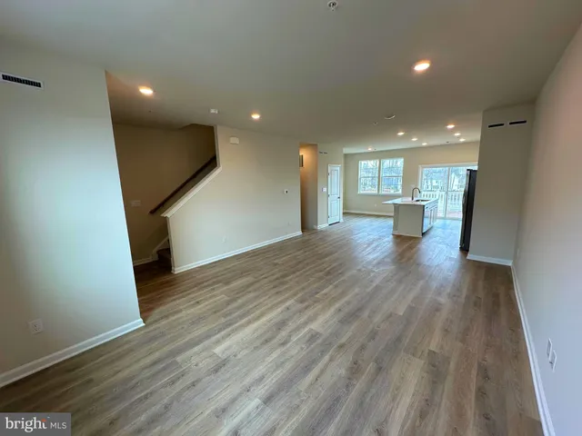 a view of a big room with wooden floor and a window