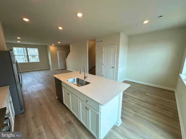 a kitchen with a sink and wooden floor