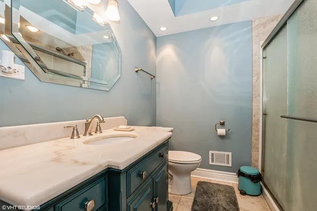 a bathroom with a granite countertop sink a toilet and a mirror