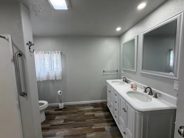 a bathroom with double vanity and two mirrors