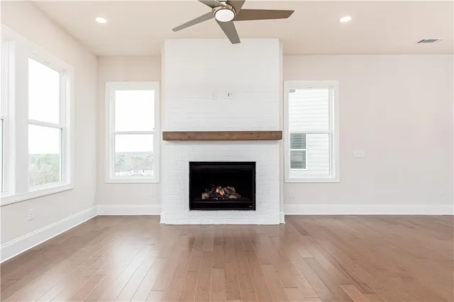 an empty room with windows and a fireplace