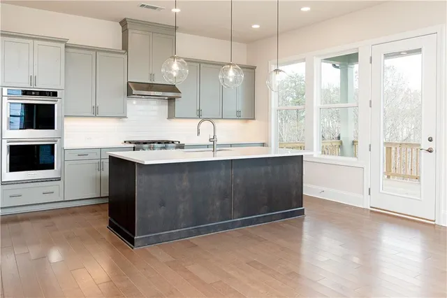 a kitchen with stainless steel appliances granite countertop a stove a sink and a refrigerator